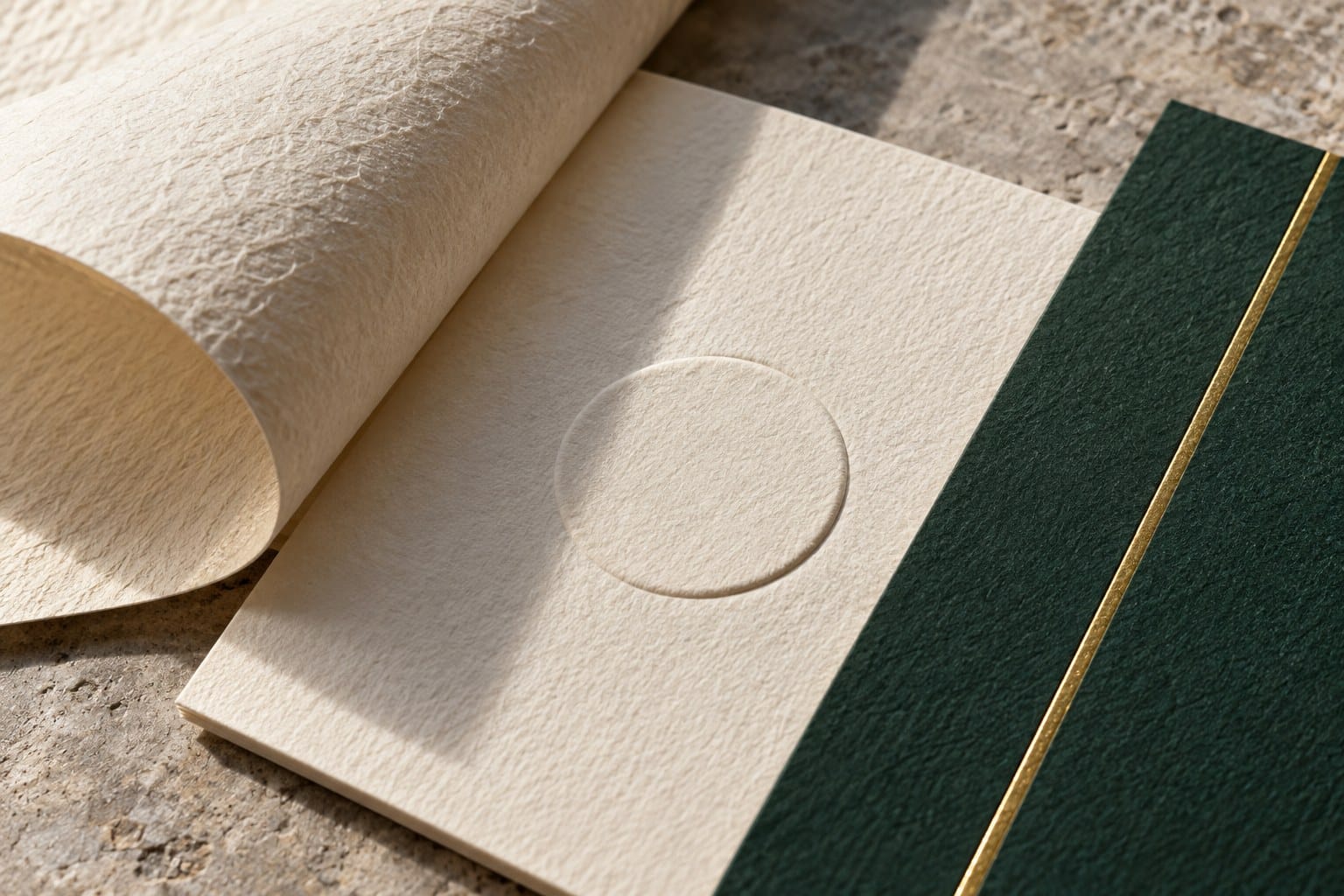 Ivory textured paper, a blind embossed circle, and a fine gold foil line on green board